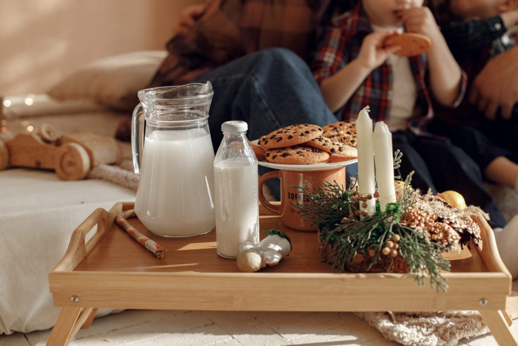 A couple eating chocolate chip cookies and drinking milk as a way to stay sober during the holidays.